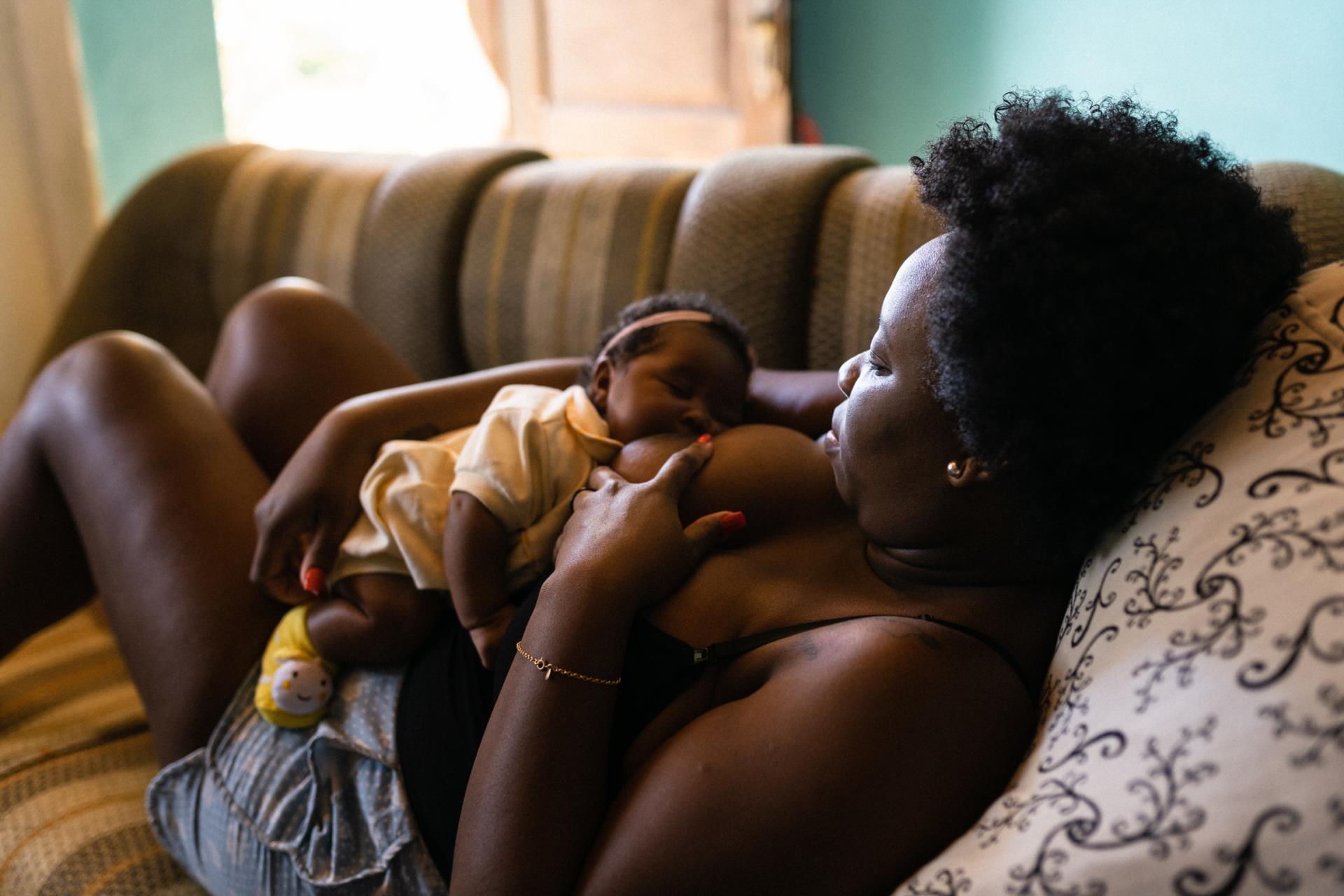 Person breastfeeding an infant in laid-back position